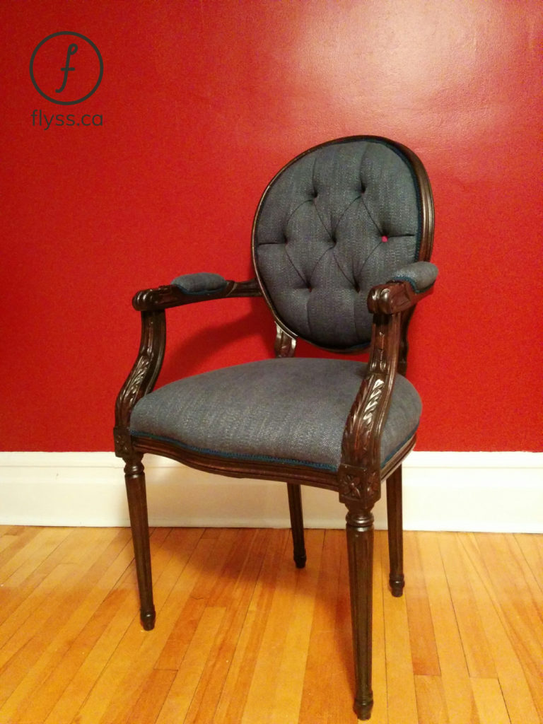 Fauteuil en bois sculpté rembourré en tissu gris capitonné